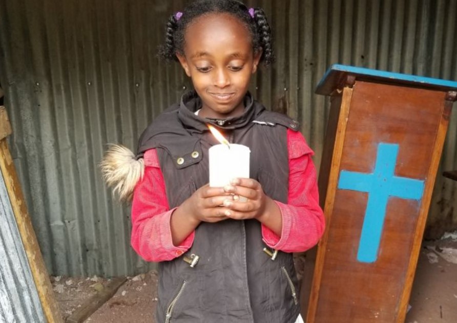 Hawi, 9, da Etiópia, com sua vela de Natal Open Doors