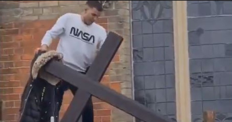 Homem arrancando cruz