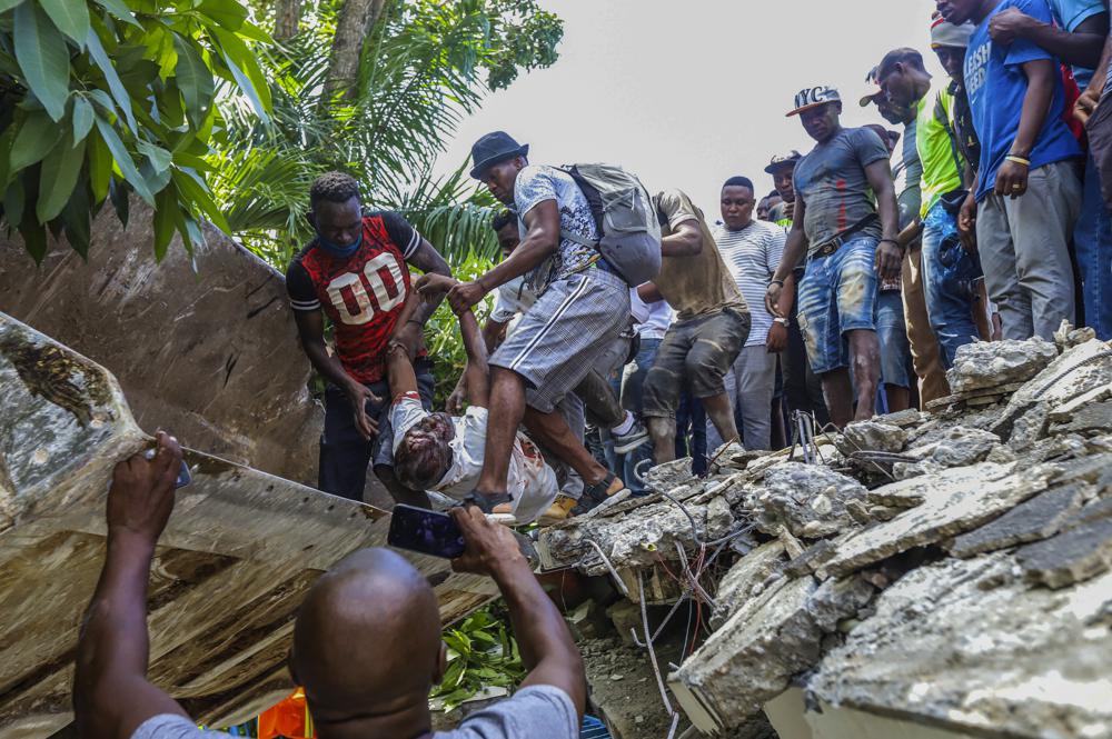 Homens resgatam feridos no Haiti