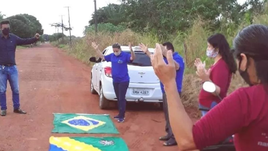Moradores oram com a bandeira do Brasil e do estado