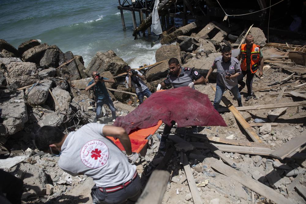 Palestinos tiram um corpo de escombros em Gaza